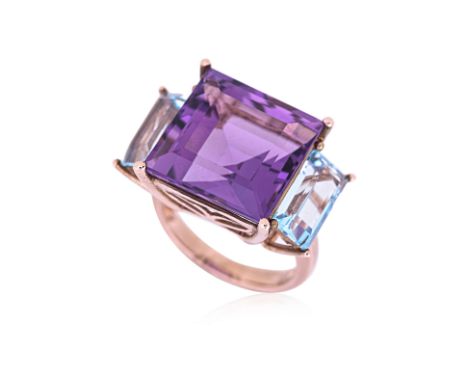 AN AMETHYST AND TOPAZ THREE STONE RING Featuring a square cut amethyst weighing approximately 15.0 Cts, flanked by two blue t