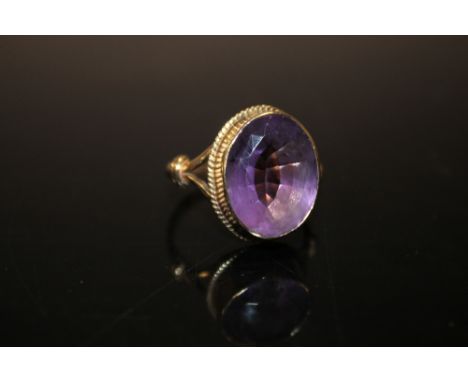 A LARGE AMETHYST DRESS RING, on yellow metal band stamped 9ct, the oval amethyst measuring approximately 16 x 12 mm, ring siz