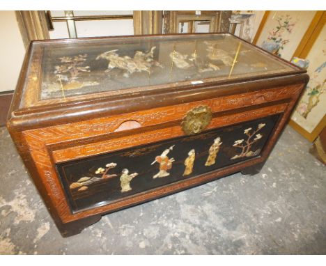 AN ORIENTAL SHIBAYAMA STYLE EBONISED STORAGE / BLANKET CHEST, having glazed panel to top, the decoration with soapstone, cora