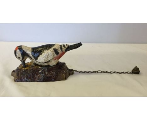 A cast iron reproduction woodpecker door knocker.