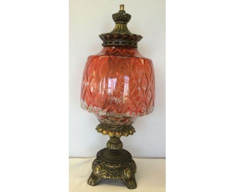 A large gilt metal table lamp with red painted glass shade.