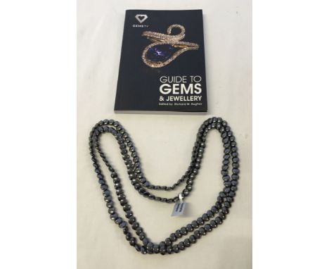 A boxed 48 inch haematite necklace with a Guide to Gems & Jewellery book.