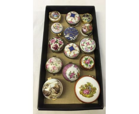 A collection of 14 ceramic decorated trinket/pill boxes with hinged lids. Includes hand painted examples.