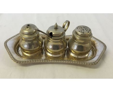 A silver plated condiment set with blue glass liners.