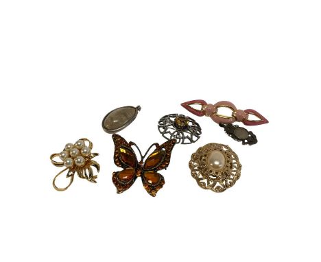 A white metal Scottish Celtic brooch set with a citrine coloured stone and various other gold coloured brooches, including a 