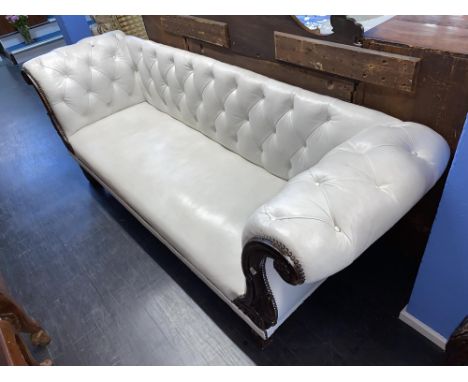 A white leather and carved oak framed button back settee