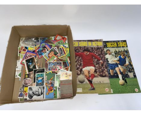 A box of Topps football cards, Soccer Stars in Action picture stamp albums and coins