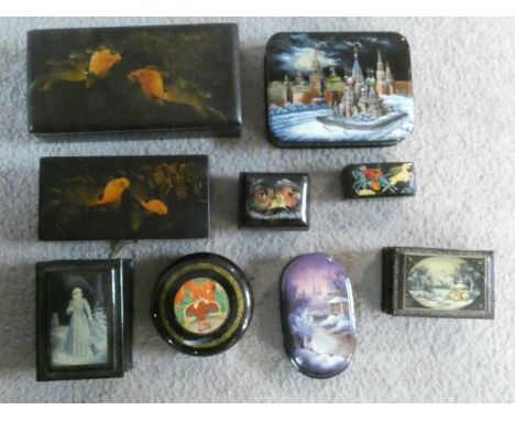 A collection of nine black lacquered trinket and pill boxes, Russian, Japanese and Indian each with hand painted decorated li