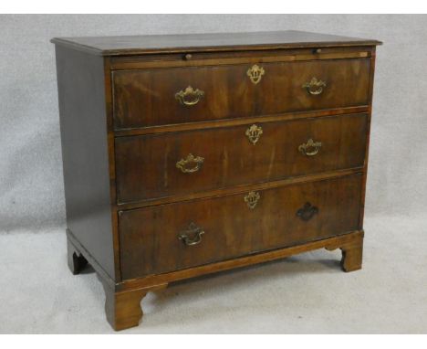 A Georgian walnut chest of three long drawers fitted with brushing slide raised on ogee bracket feet. H.91 W.108 D.57cm (base