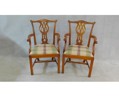 A pair of Chippendale style mahogany open armchairs with carved back splats and drop in seats on reeded square section suppor