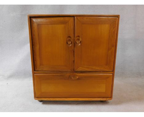 A vintage elm Ercol cabinet with panel doors and drop down base door fitted for HI Fi. H.94xW.85xL.50cm 