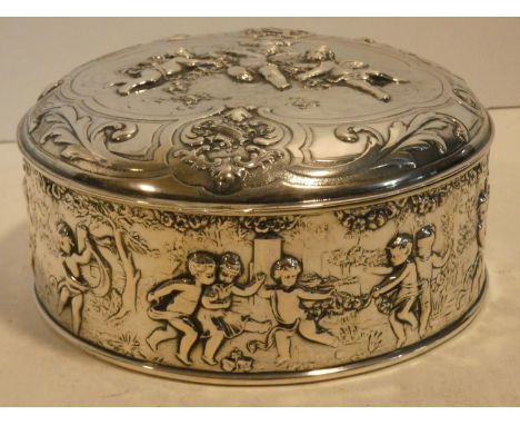 A Continental white metal hinged lidded caddy with gilded interior decorated with repousse repeating dancing putti decoration