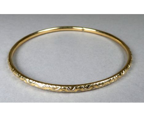 A yellow metal bangle - foliate engraved, weight 12g.