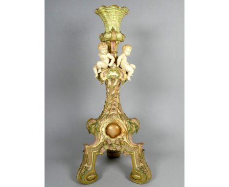 A Royal Worcester Rococo style candlestick - mounted with putto and blush decorated in pinks and greens with gilt highlights,