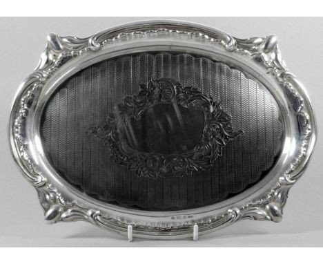 An oval silver waiter - Birmingham 1913, Charles Weale, with engine turning and engraved foliage, width 30cm, weight 540g.