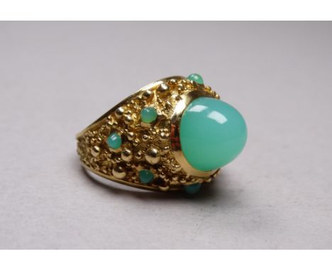 A 18ct yellow gold jade set ring - the cabochon polished stone on a field of further small stones, size M/N, weight 16.3g.