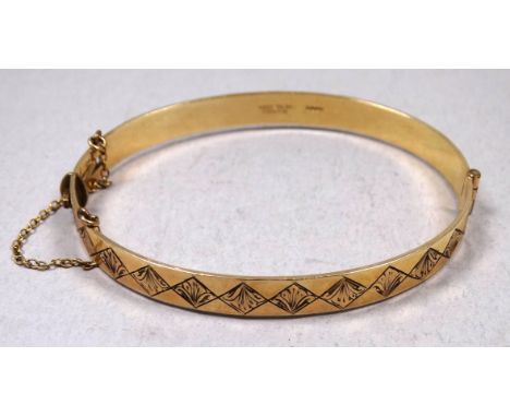 A 9ct yellow gold filled bangle - with bright cut decoration, 6cm x 5cm