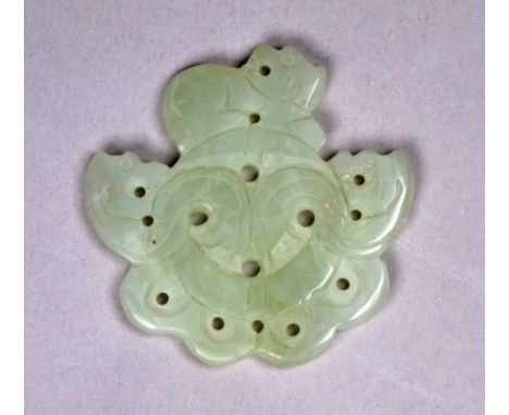A green jade pendant - carved with three dragons heads knotted about a central band, diameter 5cm.