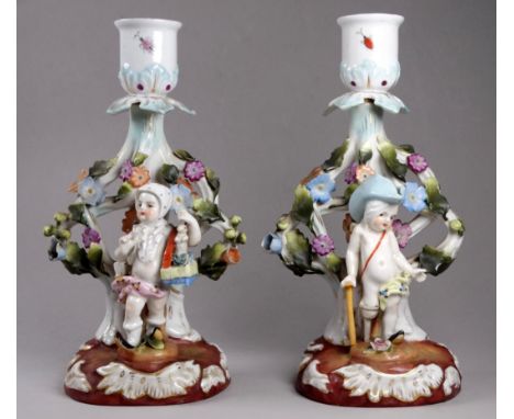 A pair of Sitzendorf candlesticks - modelled with cherubs standing on naturalistic bases, height 19cm, together with a Newpor