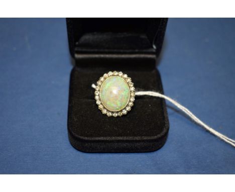 A large oval opal and diamond unmarked gold ring. 