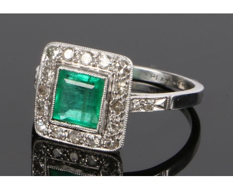 Emerald and diamond set ring, the central emerald at 0.85 carat with a diamond surround set on platinum, ring size N