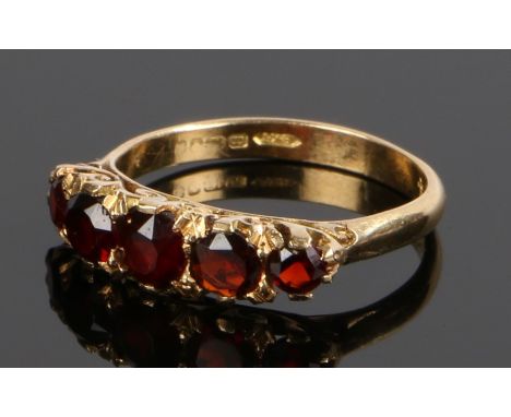 18 carat gold garnet set ring, with a row of five garnets, ring size M
