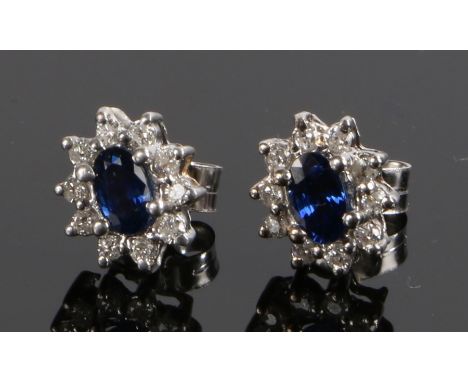 Pair of diamond and sapphire set ear studs, with a central sapphire and diamond surround to each, estimated diamond weight 0.