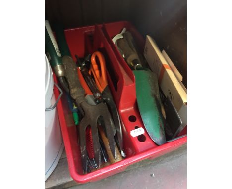 A red plastic handheld crate containing misc tools 