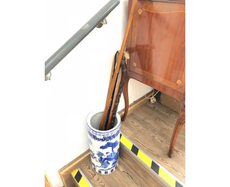 A blue and white stick stand with 5 walking sticks 