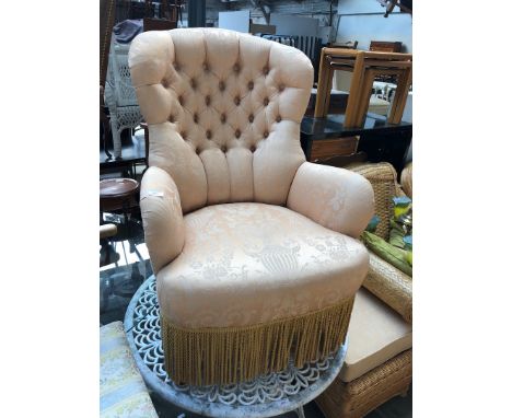 A gold floral upholstered button back armchair 