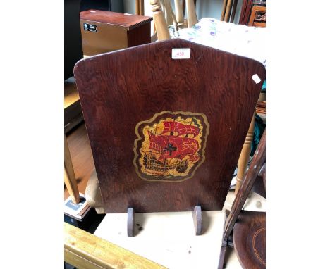 A wooden fire screen with painted ship motif 