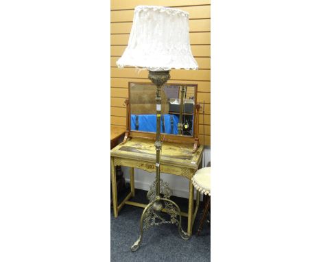 An antique brass tripod standard oil lamp converted to electrical use &amp; with elaborate decoration to the reservoir and st
