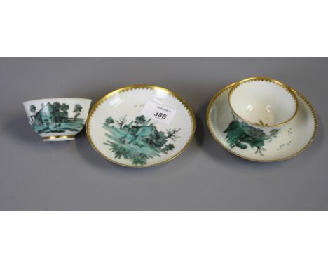 A pair of 18th century European porcelain tea bowls and saucers decorated with landscapes in green enamel within gilt borders