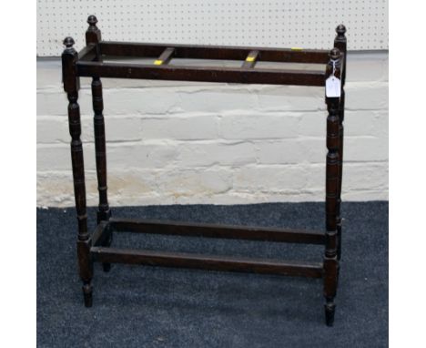 An Edwardian oak stick stand, three divisions, on ring turned tapering legs united by a box stretcher