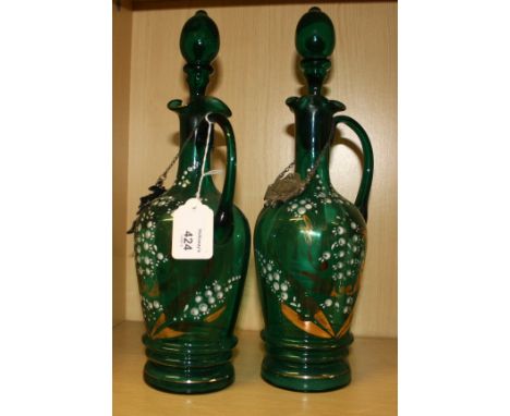 A pair of Victorian green glass spirit decanters and stoppers, each with wavy rim and elongated loop handle, the bodies decor