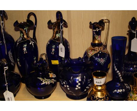 A collection of largely late 19th century Continental blue glass and enamel decorated jugs and vases, including a pair with w