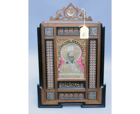 A 19th century Ottoman silk work icon depicting an Eastern orthodox priest within a bead work easel frame with a star and cre
