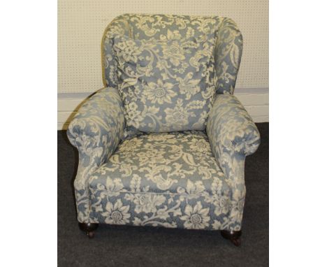 An early 20th century deep seated wing back drawing room armchair, with rolled arms, horsehair overstuffed seat on bun feet w