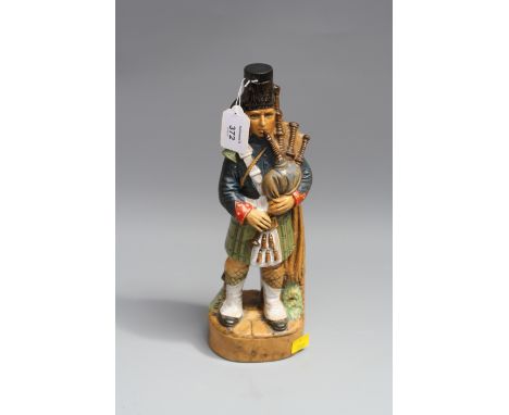An Italian K.L.E.M pottery spirit flask and stopper modelled as a Highland piper 32cm
