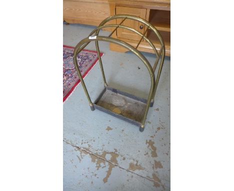 A brass and iron stick stand with an arched top 