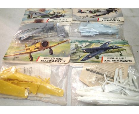 Four early Airfix bagged aircraft kits, Seahawk, Harvard, Spitfire, Whirlwind, appear complete/unchecked. UK P&amp;P Group 1 