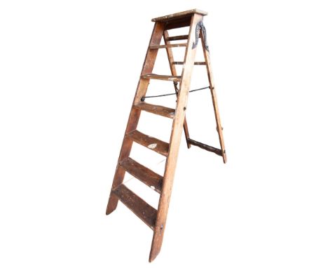 A vintage 6 rung Simplex wooden step ladder, cast iron supports and central supports, approx 142cm high 
