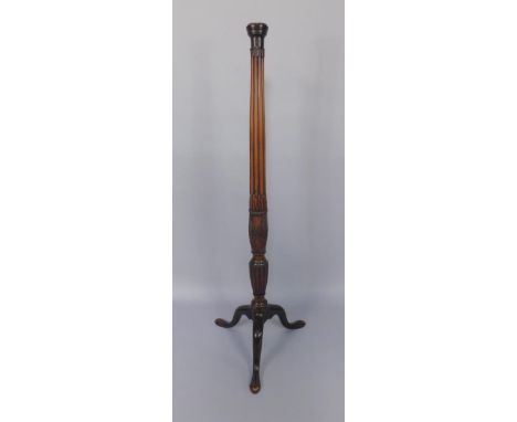 A carved mahogany bed post now converted to a floor lamp, with tripod legs. 