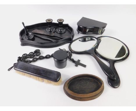 An ebony 20thC dressing table set, comprising serpentine tray, pair of candlesticks, piano shaped jewellery box, trinket jar 