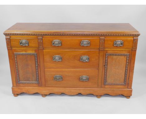 A Victorian mahogany dresser base, with three long drawers flanked by drawers over cupboard doors, raised on a bracket base a