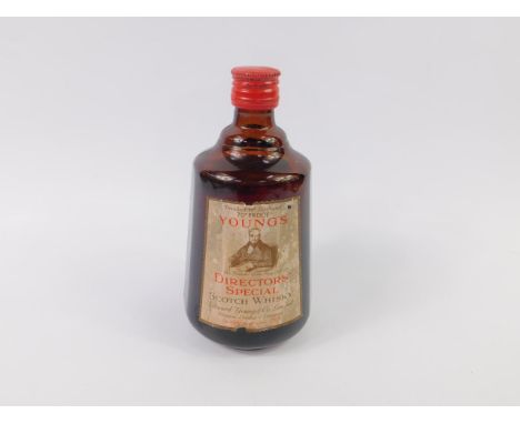 A bottle of Young's Directors Special Scotch Whisky, red screw cap, shoulder level. 