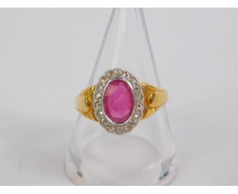 A 22ct gold ruby and diamond ring, the oval cut ruby in a surround of diamonds, ruby approx 1 1/4cts, diamonds 0.2cts, size P