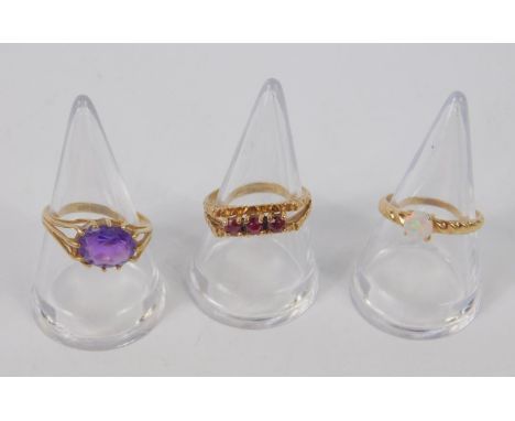 A 9ct gold and amethyst single stone ring, oval claw set, size N, opal ring set in yellow metal, stamped 9ct, size M, and a 9