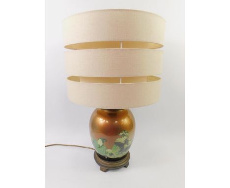 A Japanese lacquered glass retro table lamp decorated with figures from theatre, with a fabric shade, 57cm high.