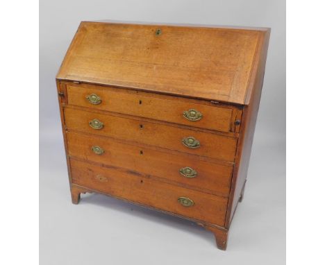 A George III oak bureau, the fall flap opening to reveal a fitted interior, over four long graduated drawers, raised on brack
